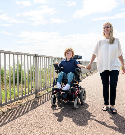 Mother and son hold hands.