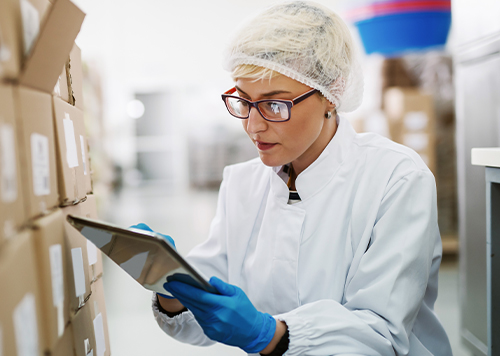 Woman in storage area with an iPad. 