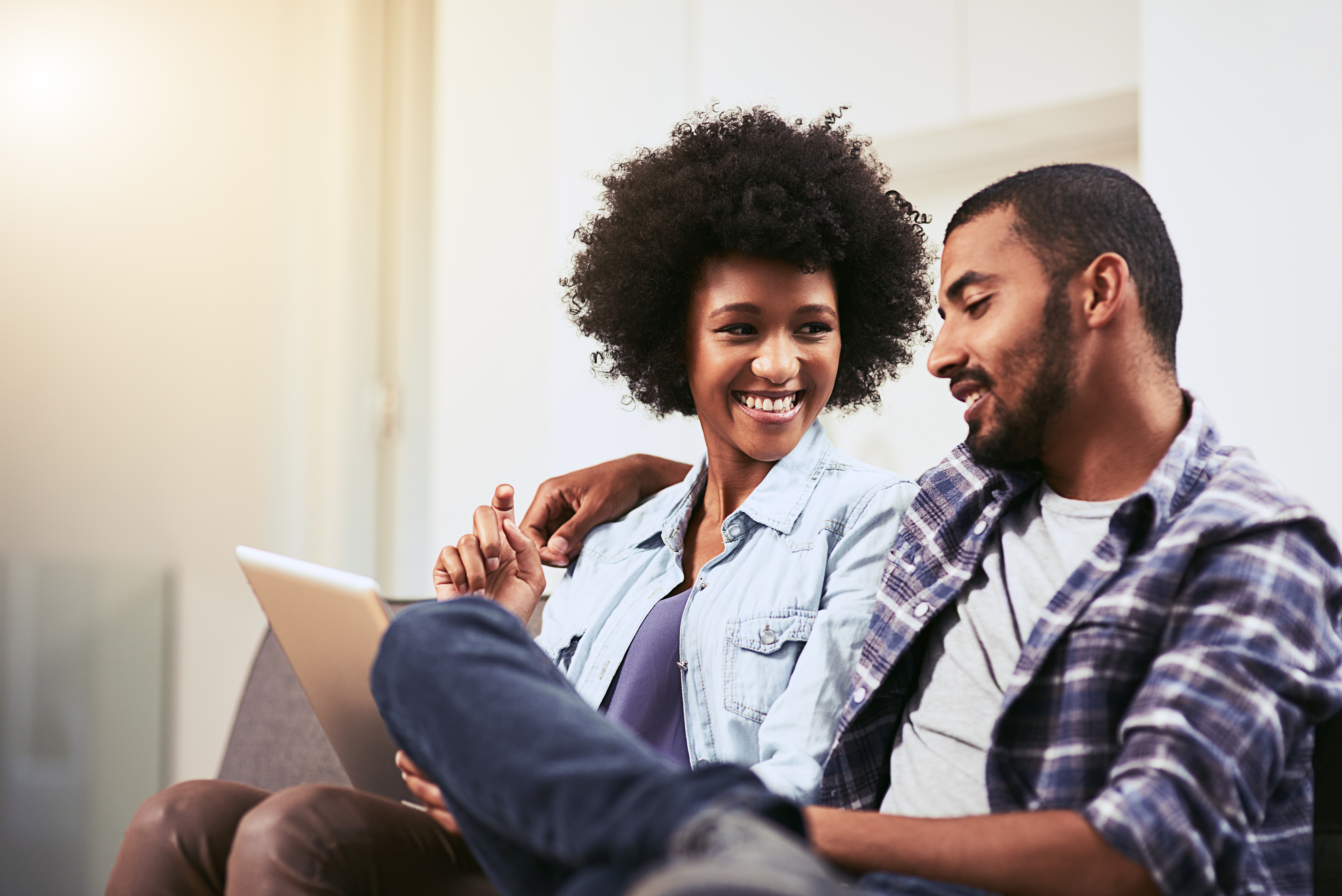 Couple smiling while looking at computer. 