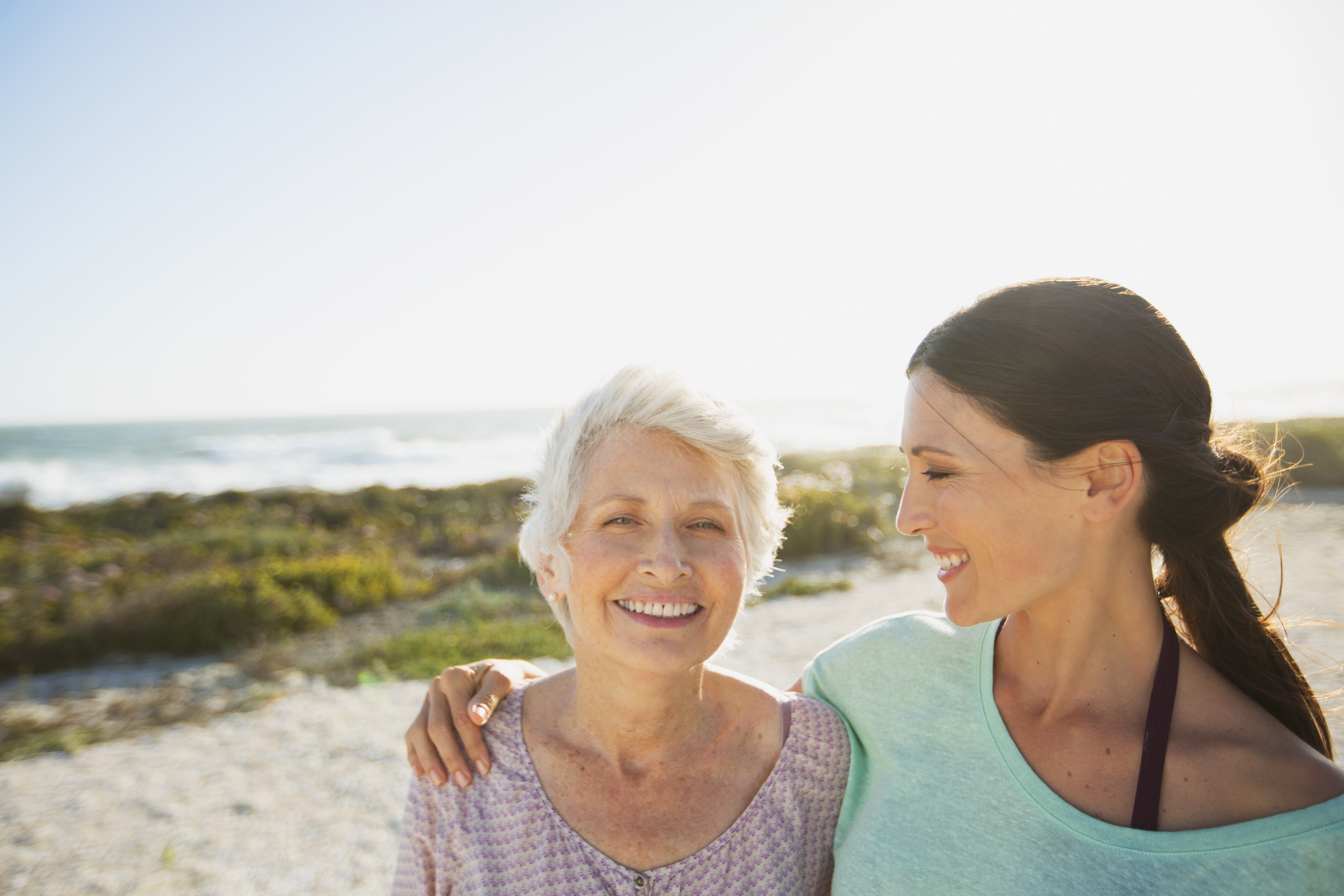 Mother and daughter smiling on beach