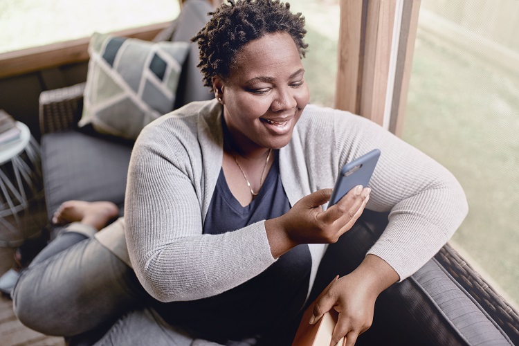 woman on couch looking at phone