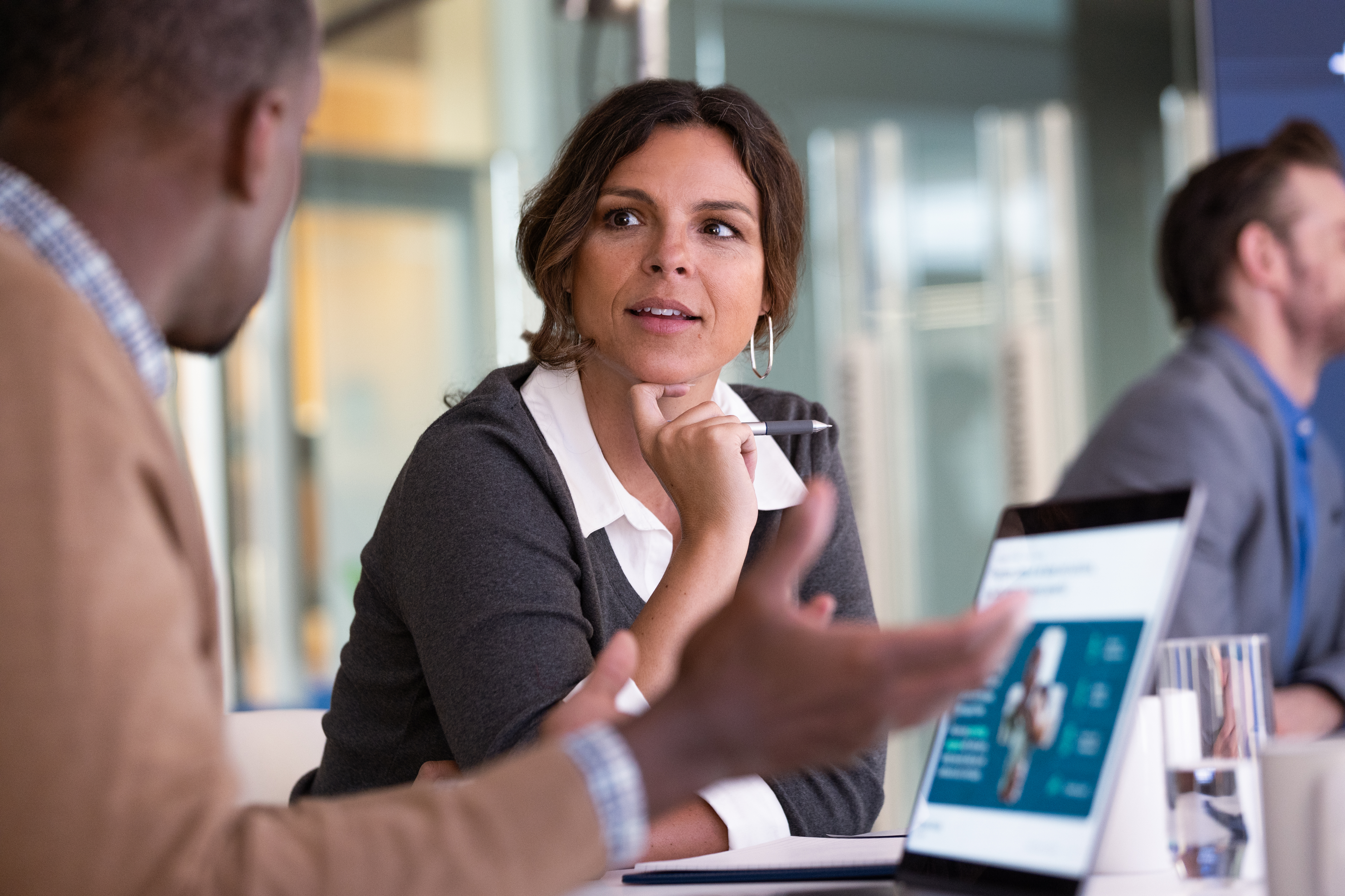 Woman listening to man talk with laptop