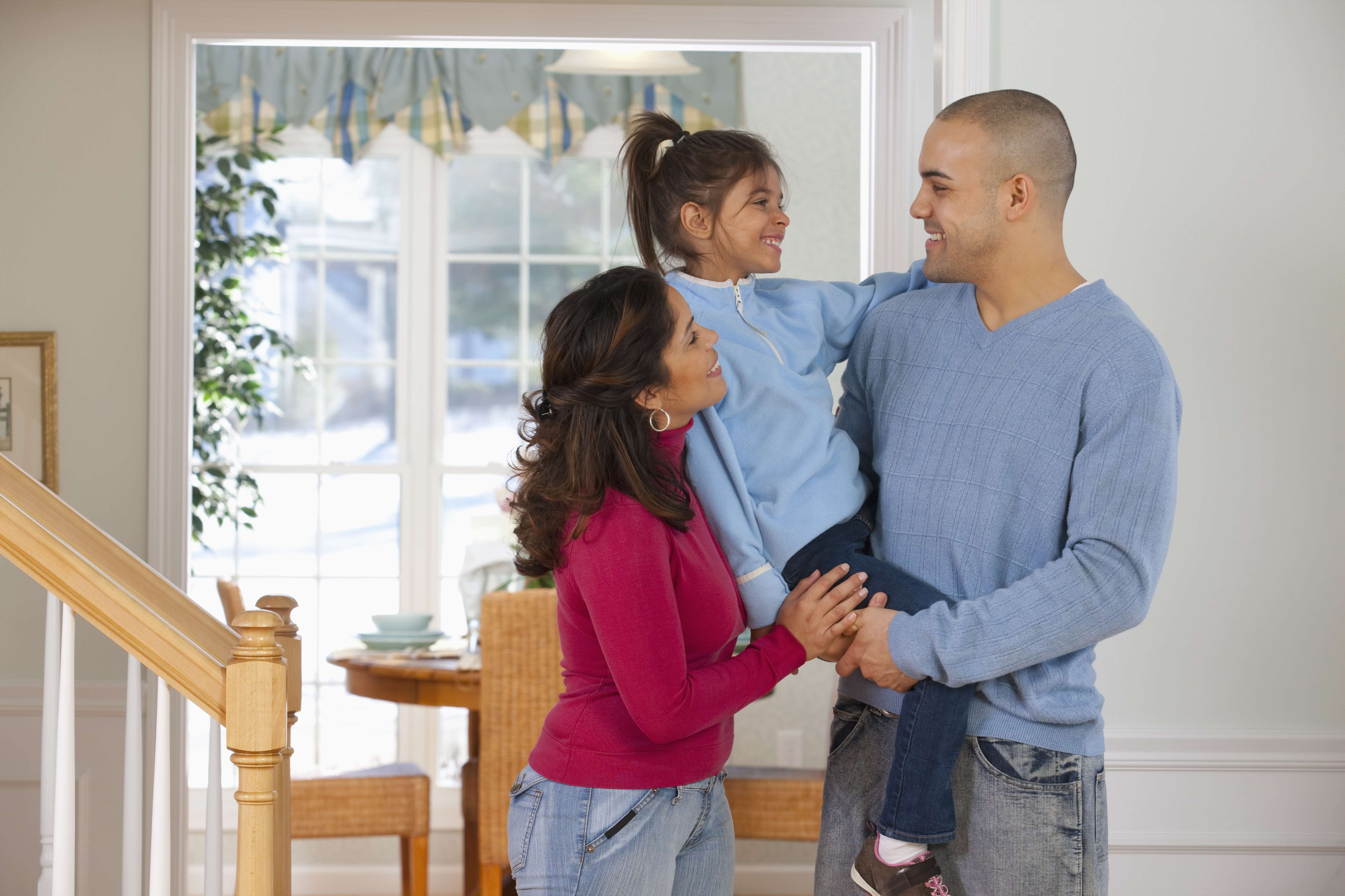 Mother and father holding daughter. 