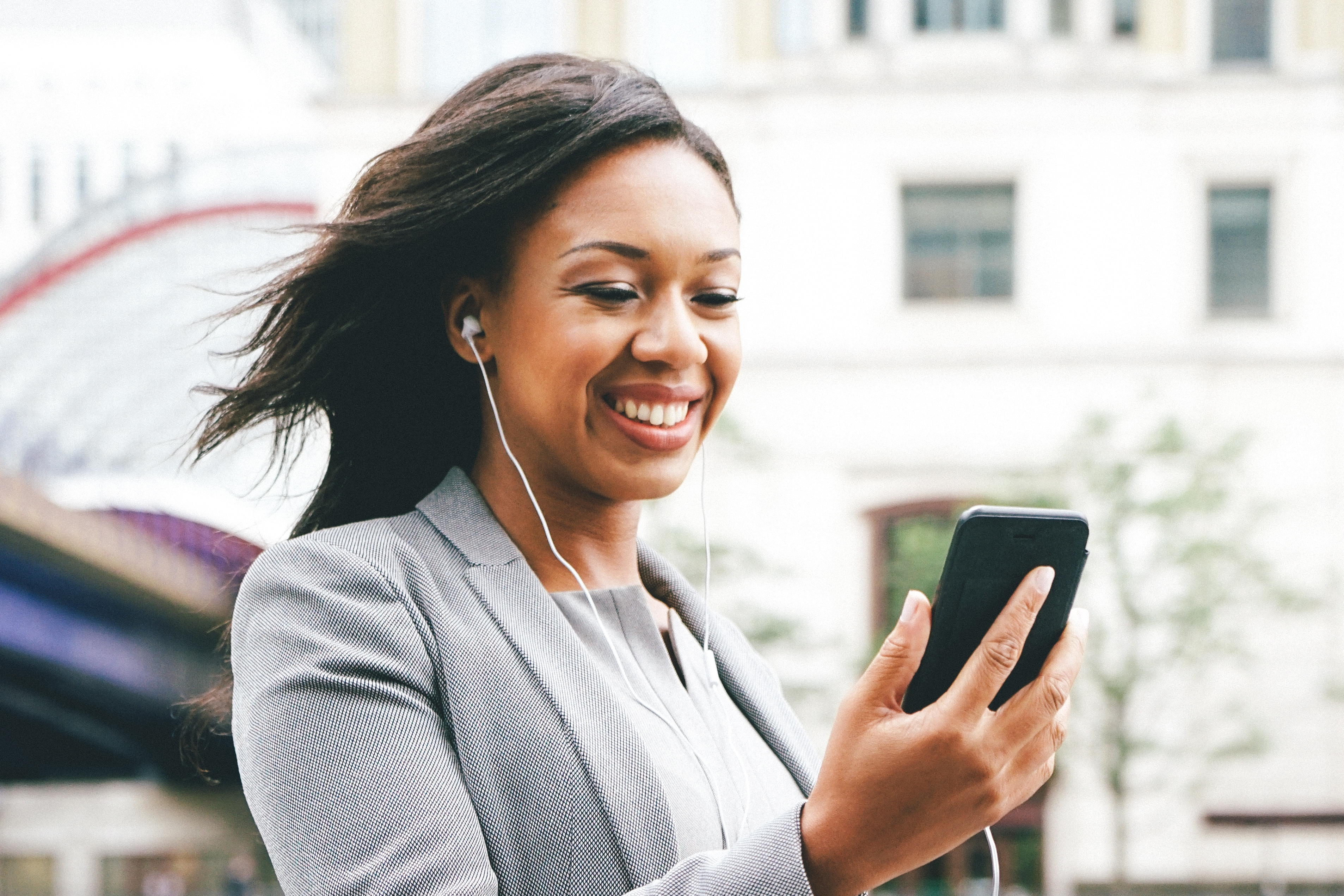 Woman holding phone and smiling. 