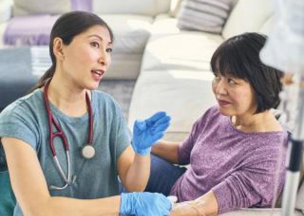 A nurse speaks with a patient during the at-home infusion process.